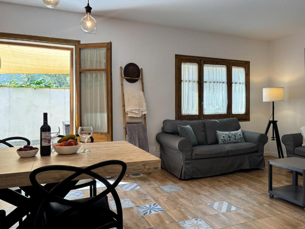 a living room with a table and a couch at Ca La Fustereta in Figueres