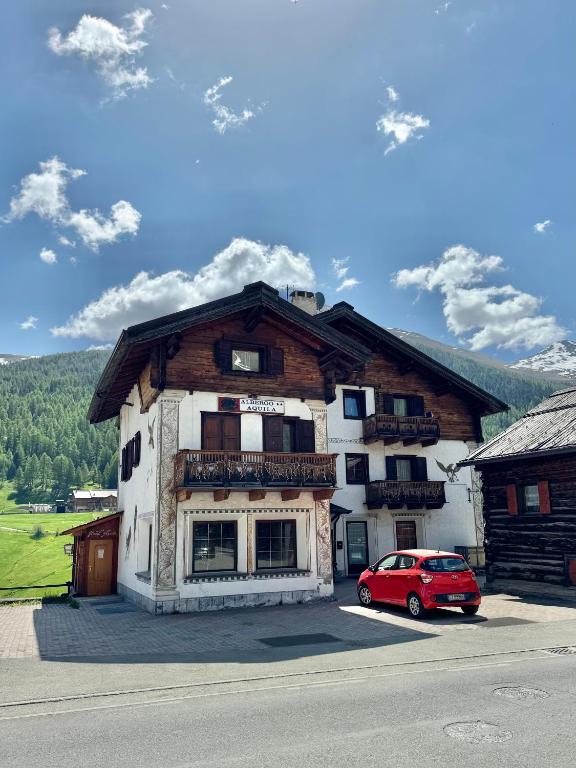 a red car parked in front of a building at Hotel Aquila in Livigno