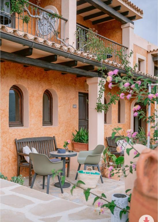 a patio with chairs and a table in front of a building at Casa Naya Ibiza in Sant Llorenç de Balafia