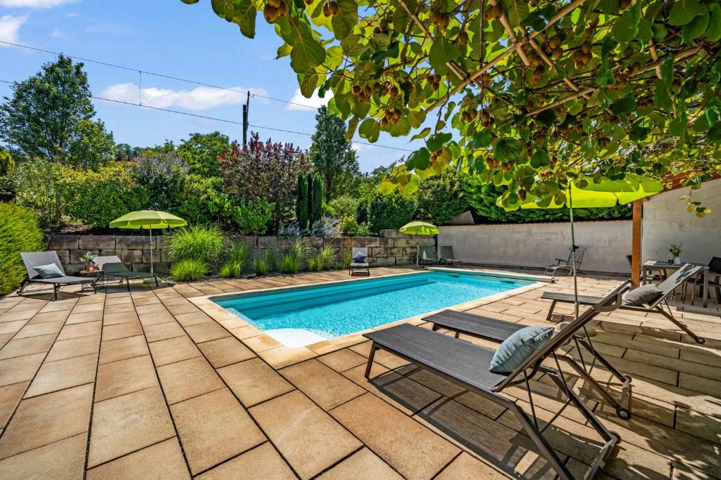 a swimming pool in a yard with chairs and an umbrella at Weingut Landerer in Vogtsburg