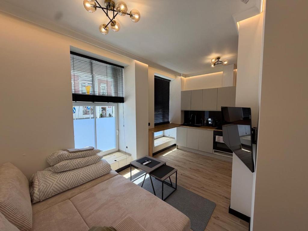 a living room with a couch and a kitchen at Apartament Ania Nysa Centrum z bezpłatnym parkingiem in Nysa