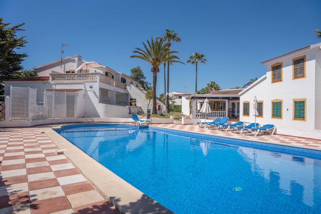 a swimming pool in front of a house at Villa Noa in Cala en Bosc