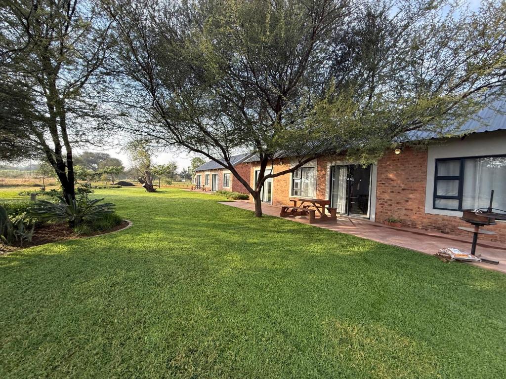 a yard with a house and a picnic table at ValView Guest Lodge in Thabazimbi