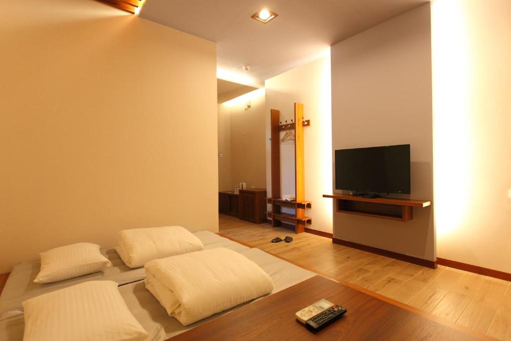 a living room with a bed and a flat screen tv at Toutsu Gyoen in Donggang