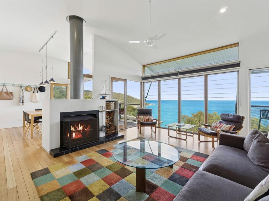 a living room with a fireplace and a table at Wye View in Wye River