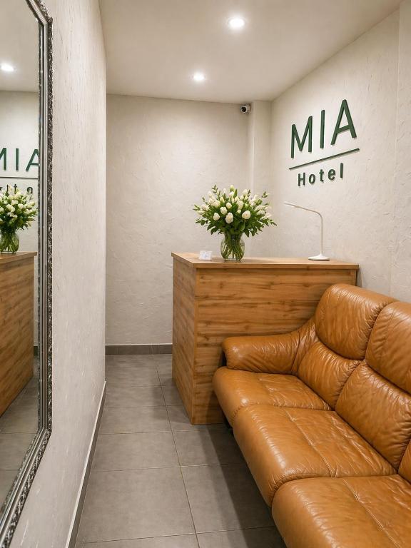 a leather couch in a dressing room with a mirror at Mia Hotel in Rivne