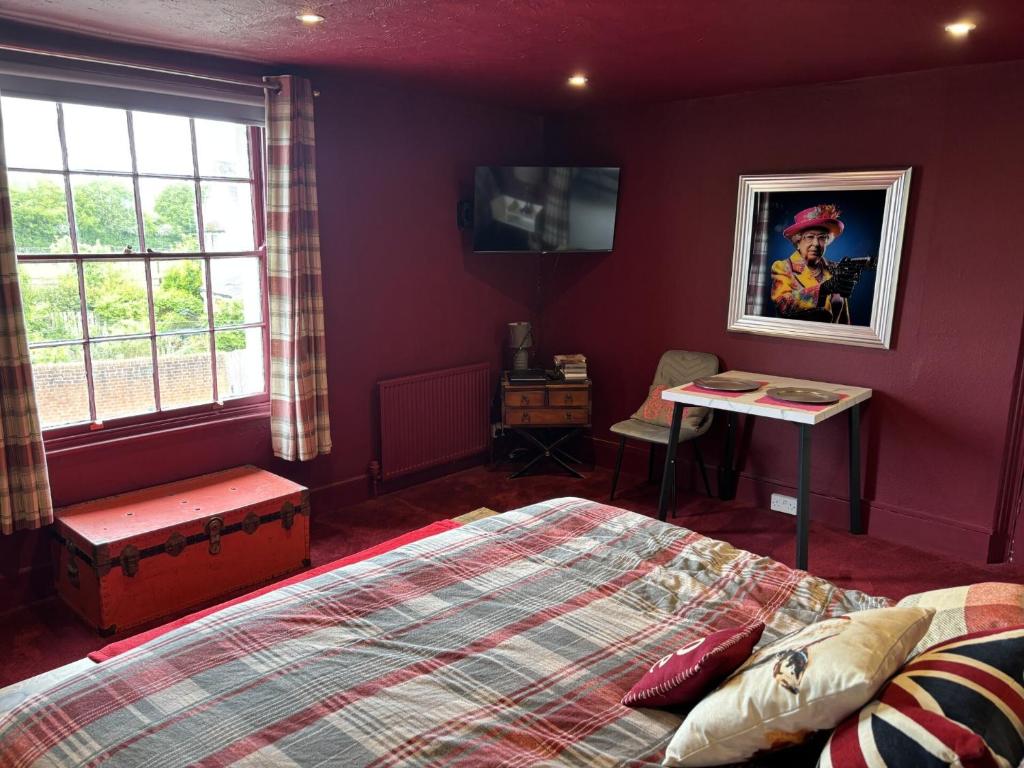 a bedroom with a bed and a table and window at The Flat The Plough in Birdbrook