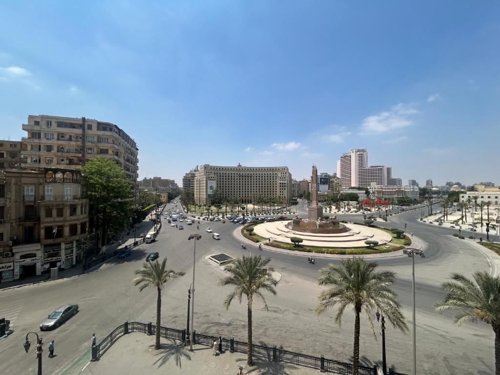 a city with a street with cars and palm trees at Grand lotus hotel downtown in Cairo