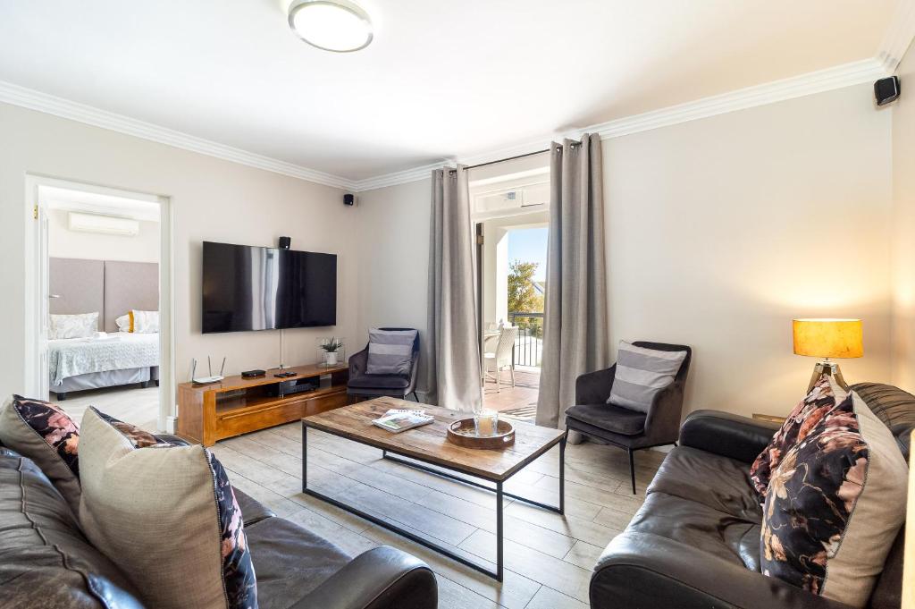 a living room with a couch and a table at Winelands Golf Lodges 24 in Stellenbosch
