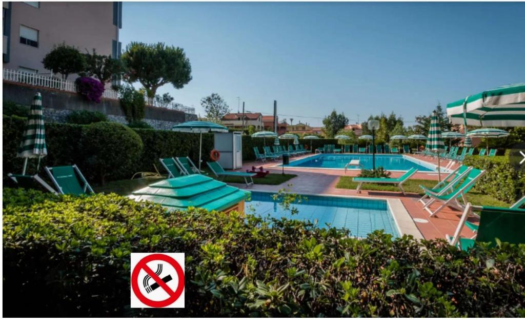 a swimming pool with a no swimming sign next to it at Rifugio del Mare con piscina e palestra in Loano