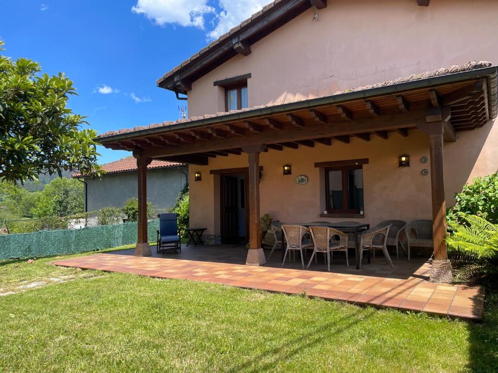 a patio of a house with a table and chairs at VILLA ISABEL in Piloña