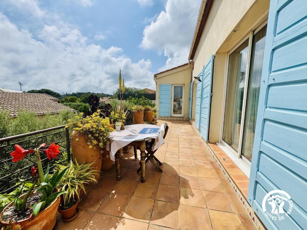 a patio with a table on a balcony at Entre mer et village in Leucate