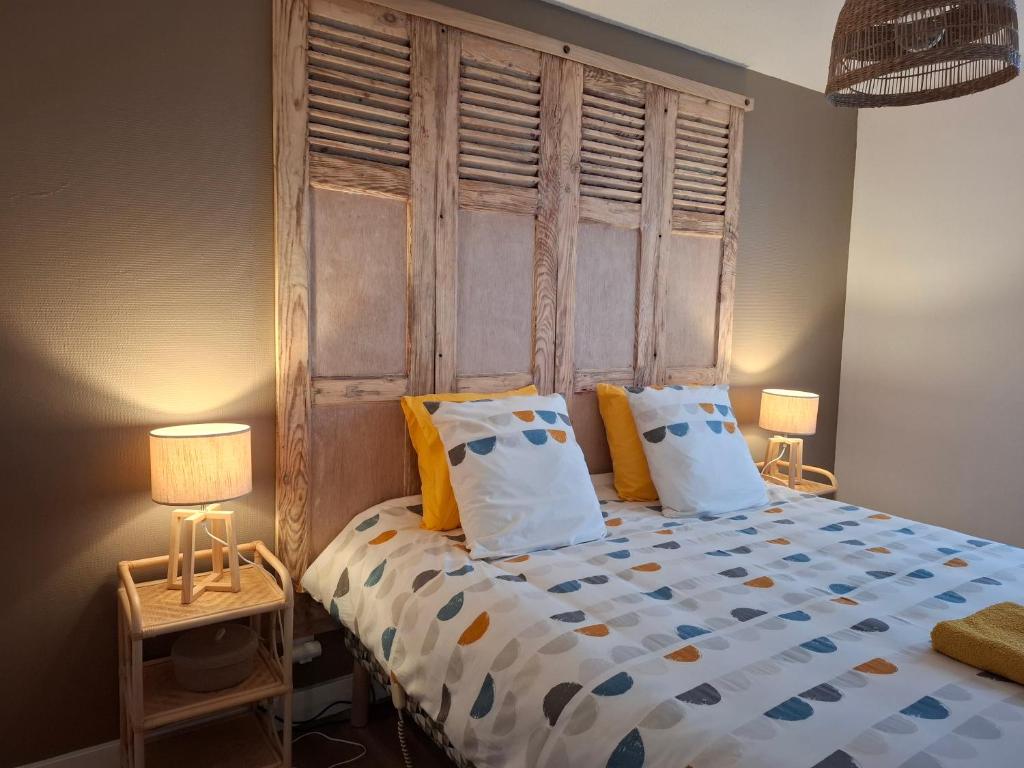 ein Schlafzimmer mit einem großen Bett und zwei Lampen in der Unterkunft Le3cent85 in Saint-Germain-Laval