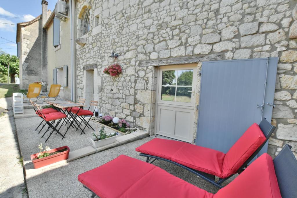 a patio with chairs and a table and a building at Clos Pimi in Monbazillac