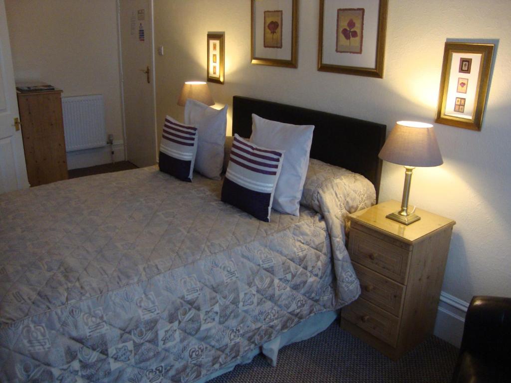 a bedroom with a bed with pillows and a lamp at The Newark in Bournemouth