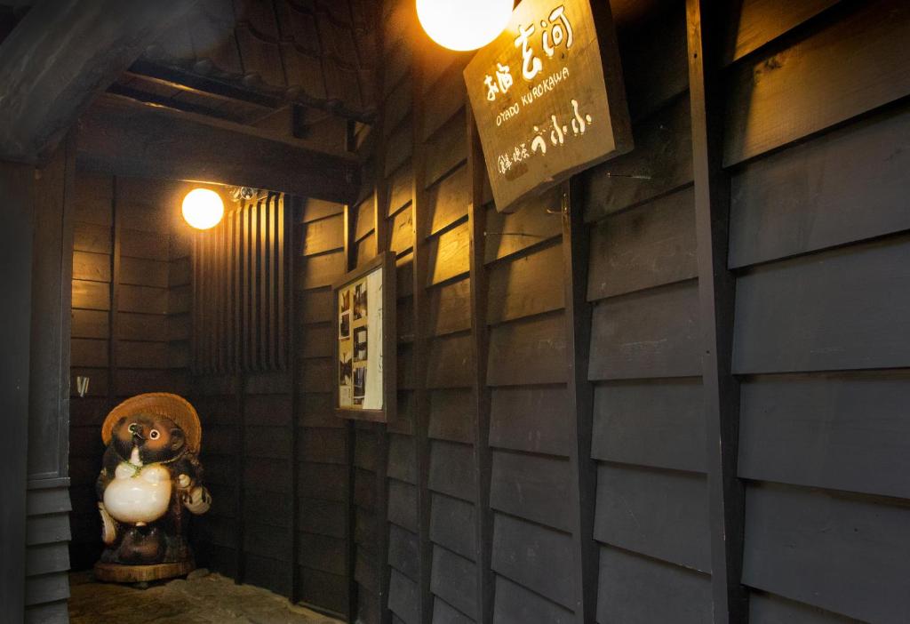 a room with a tiled wall with a statue of a person at お宿玄河 in Minamioguni