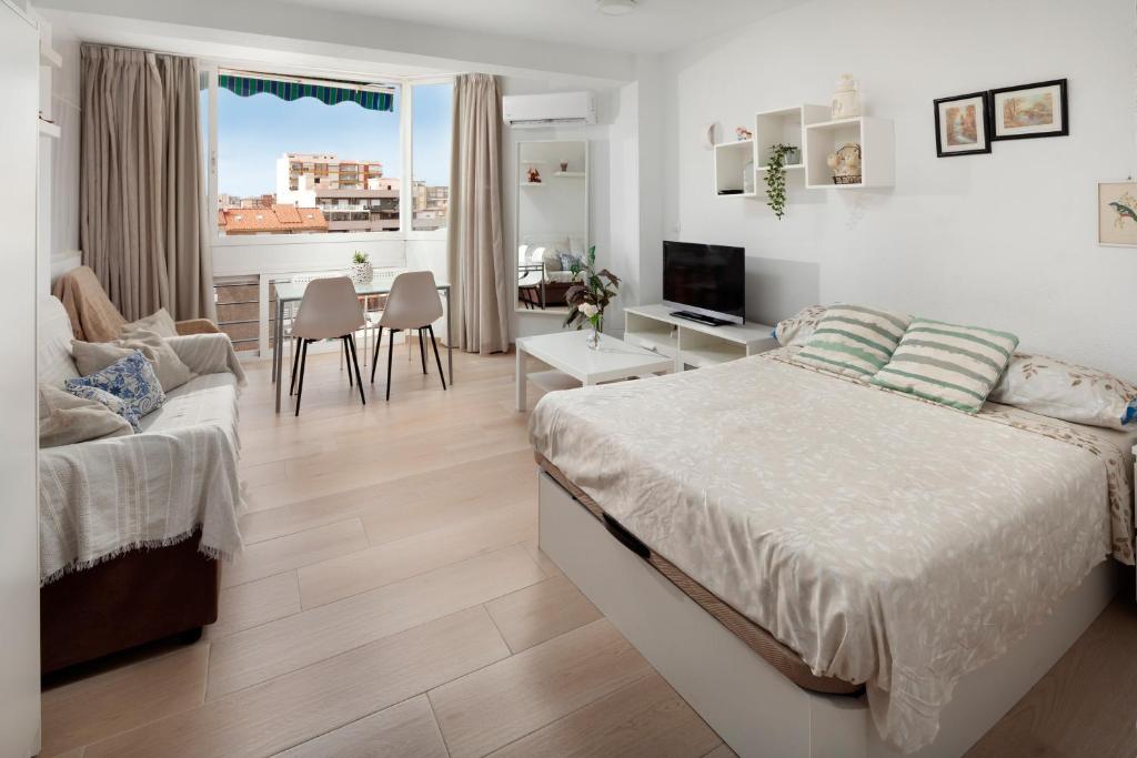 a bedroom with a bed and a living room at Sol y breeze in Torre del Mar