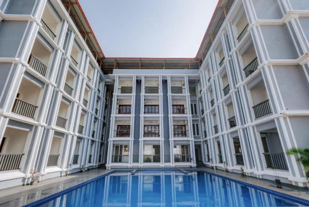 an exterior view of a building with a swimming pool at Moringa Stays Formerly Deep International in Mandrem