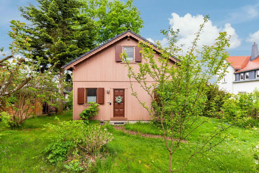 a small pink house in a yard with green grass at Ferienhaus Sonne in Hohnstein