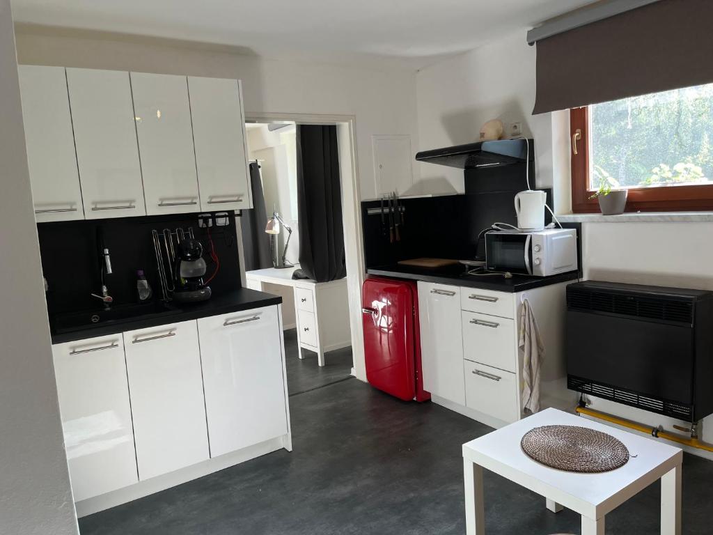 a kitchen with white cabinets and a red refrigerator at Apartmán Vodolka in Odolena Voda