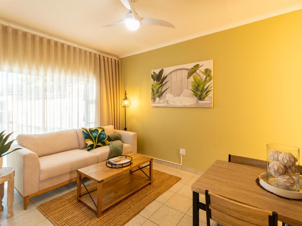 a living room with a couch and a table at Meerkat Manor Self-Catering & Accommodation Windhoek in Windhoek