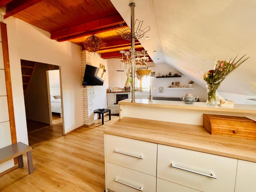 a kitchen with white cabinets and wood floors at Apartmán Pura Vida in Zaječí