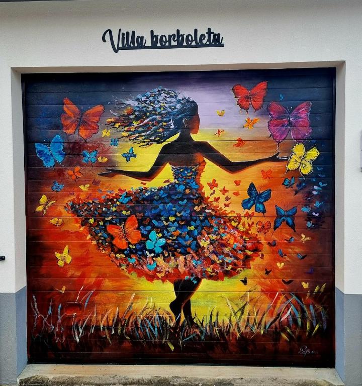 a painting of a woman in a dress with butterflies at Villa Borboleta in Santana