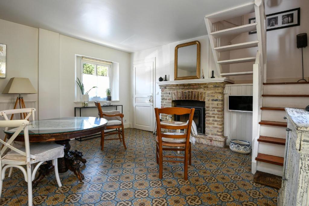 a living room with a table and a fireplace at Cottages Croix Abbé, Bergeronnette in Saint-Valéry-sur-Somme