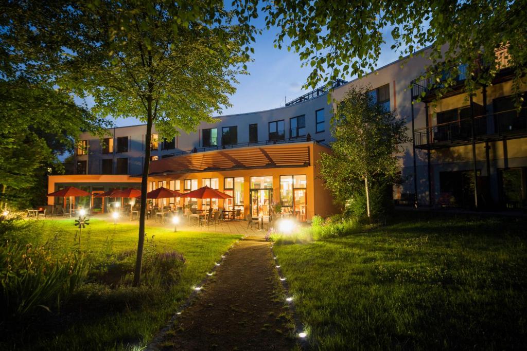 a building with lights in the grass in front of it at Heide Spa Hotel &amp; Resort in Bad Düben