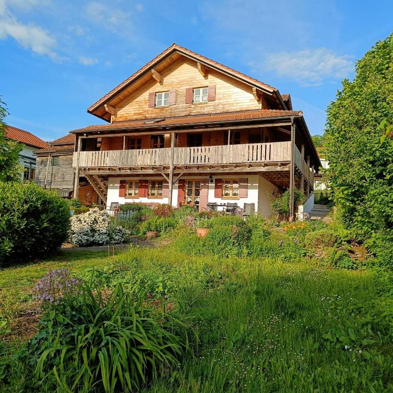 a large wooden house with a deck and a yard at Ferienwohnung Landblick Lalling in Lalling