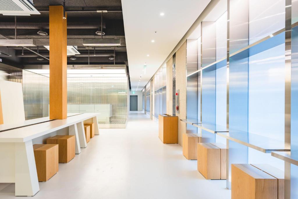 an office corridor with benches and glass walls at Takt Jongno Female Only Capsule Hotel in Seoul