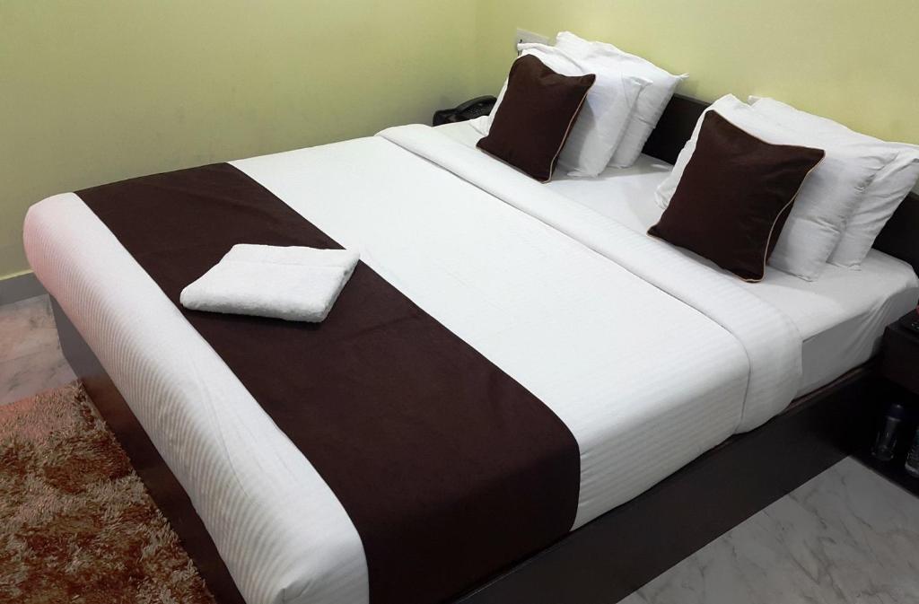 - un grand lit avec des draps et des oreillers en noir et blanc dans l'établissement Kevins Homestay, à Port Blair