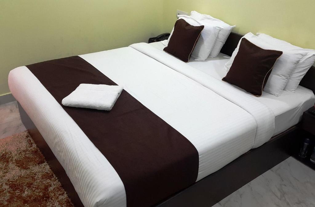 un grande letto con lenzuola e cuscini bianchi e neri di Kevins Bed & Breakfast a Port Blair