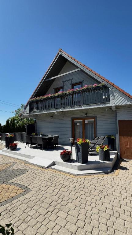 a house with a patio with potted plants on it at Ostoja Konarzewo in Pogorzelica