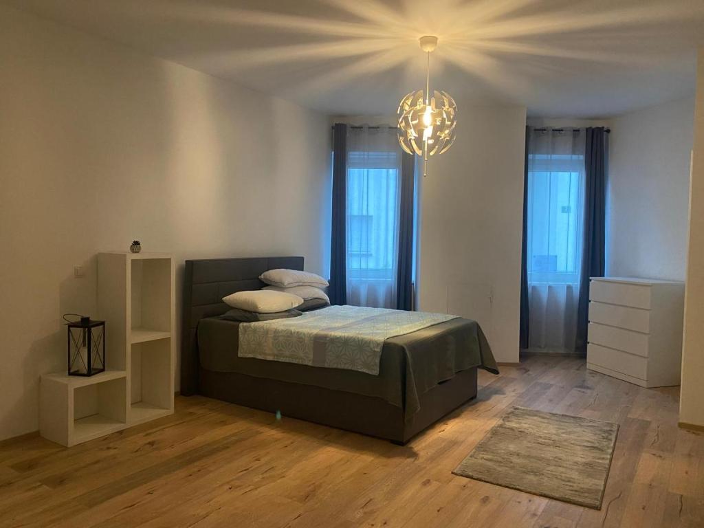 a bedroom with a bed and a chandelier at Excelsior in Graz