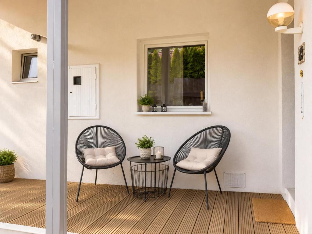 two chairs and a table on a porch with a window at Seč Aktivně in Seč