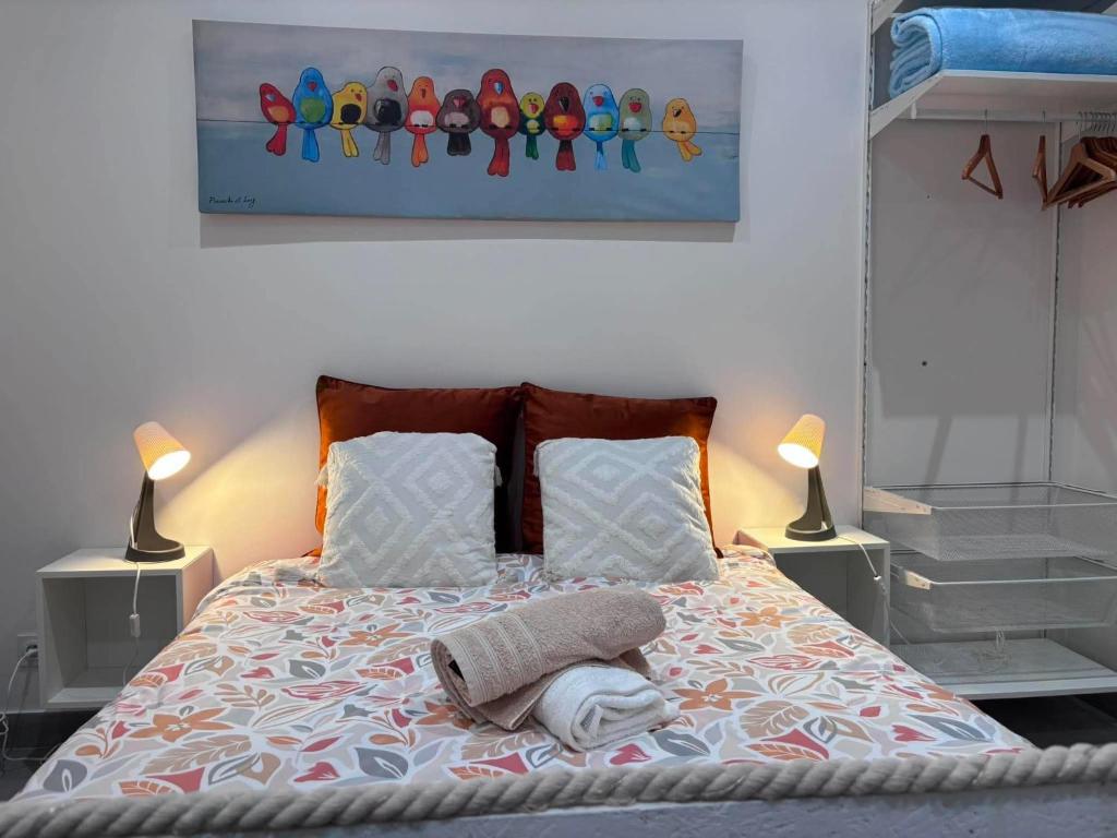 a bed with two lamps and a picture on the wall at Aulta in Ault