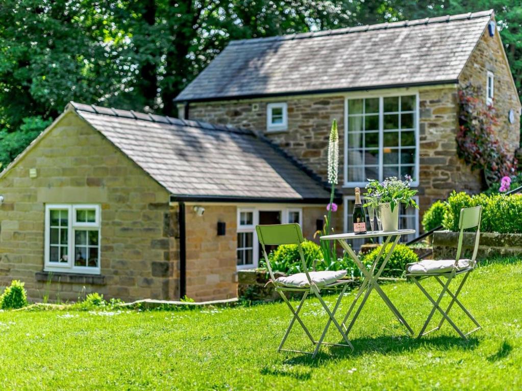 a small stone house with two chairs in front of it at 1 Bed in Dronfield oc-40971 in Chesterfield