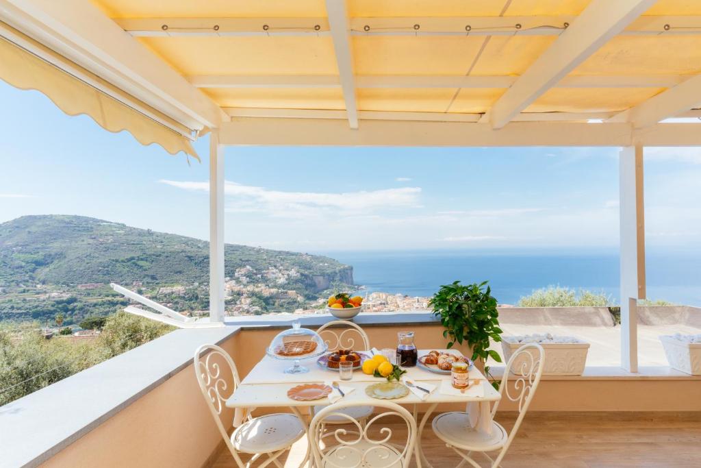 a table and chairs on a balcony with a view of the ocean at casa FraLu in Vico Equense