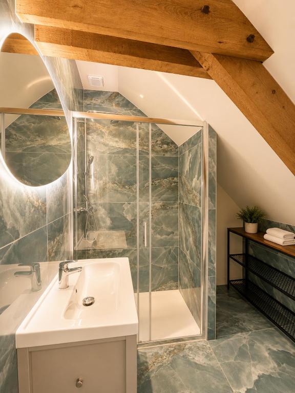 a bathroom with a glass shower and a sink at Onyx Green in Saint-Aignan