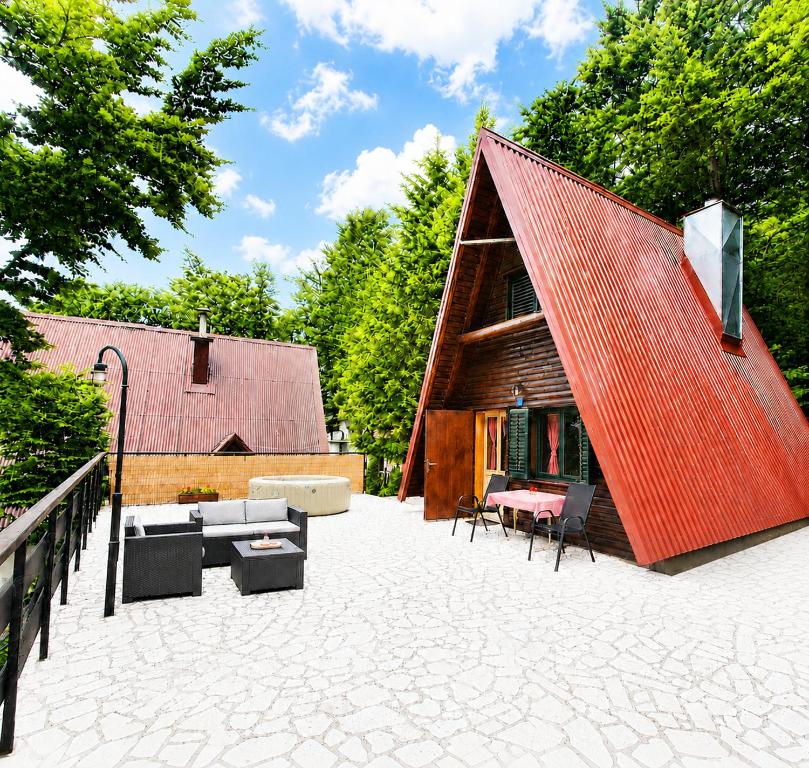 a house with a red roof sitting on a patio at Planinska kuća BRDO in Zlobin