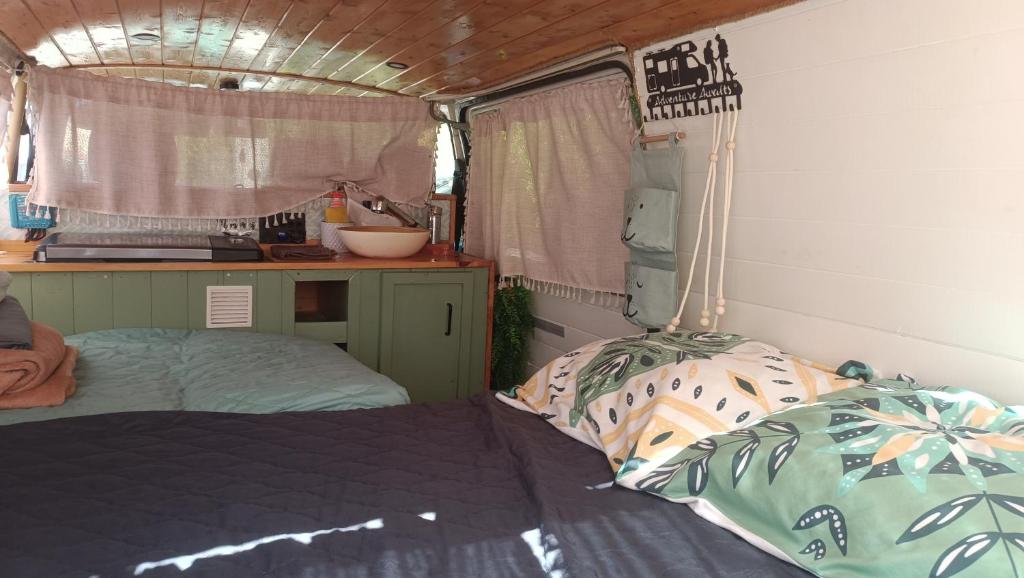 a bedroom with a bed and a kitchen in a rv at Campervan's Algarve in Albufeira