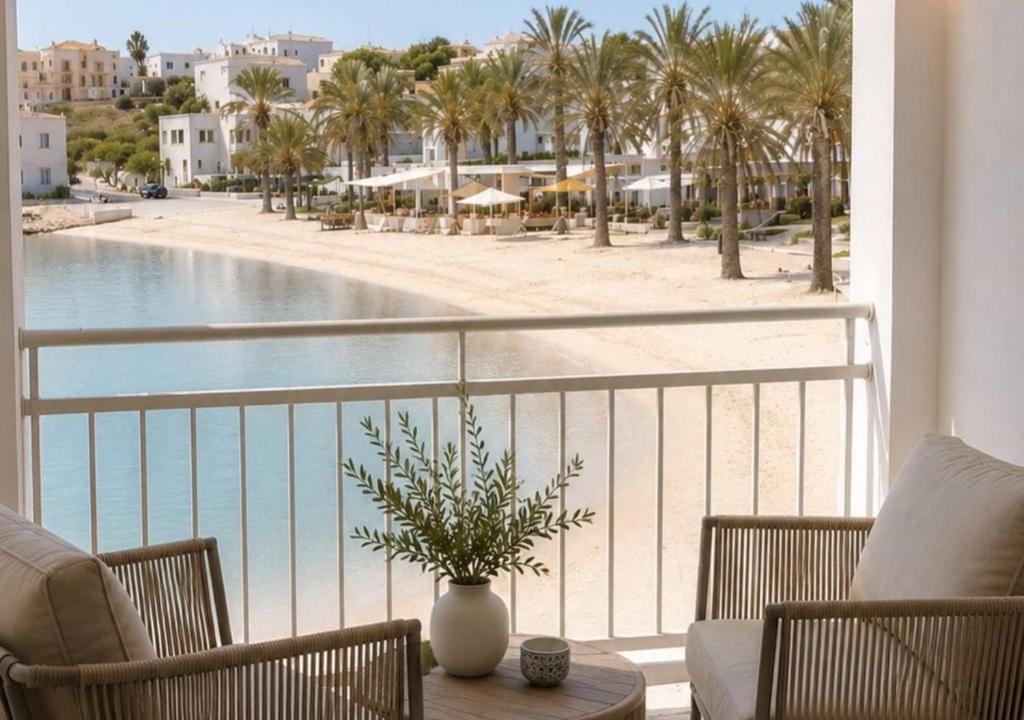 a balcony with a view of a pool and palm trees at Mareluna Luxury Accomodation in Lampedusa