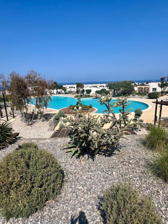 a resort with a pool with blue water and plants at Sea View Pool 2BR Esentepe in Kalogrea