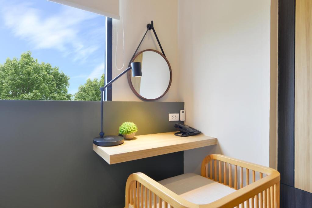 A compact wall-mounted desk beside a window and wooden chair.
