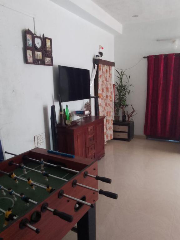 a living room with a pool table and a tv at Coorg climate stay in Madikeri
