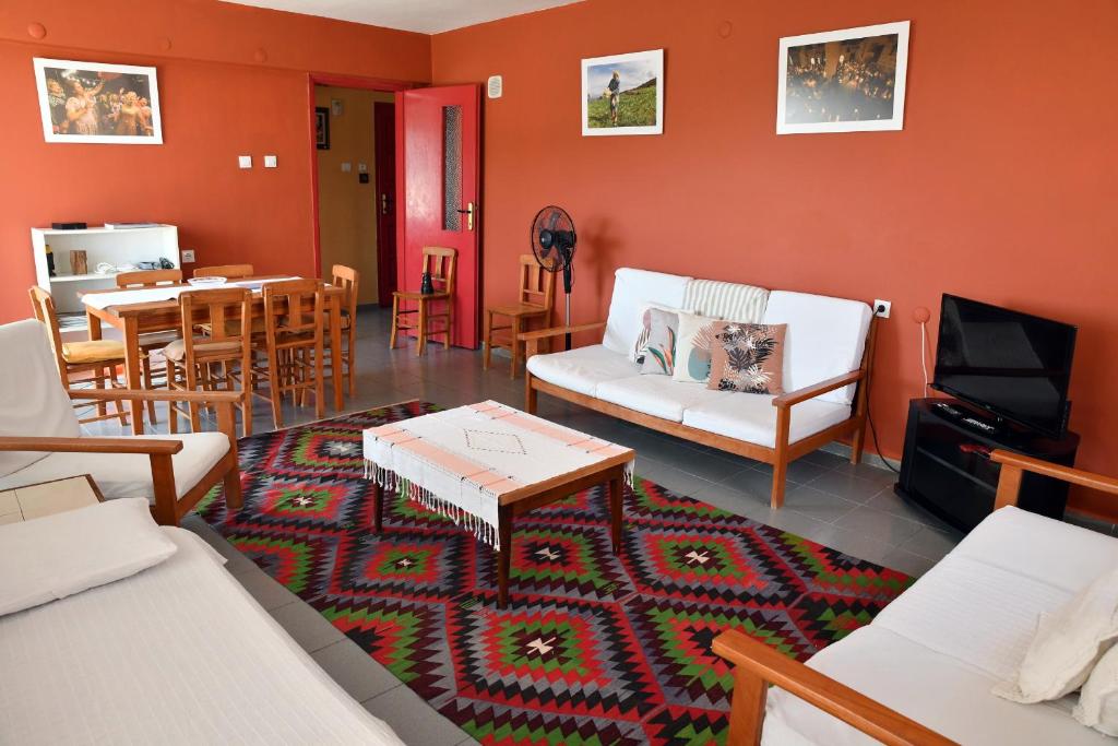 a living room with a couch and a tv and a table at Mimas Garden Apartments in Karaburun