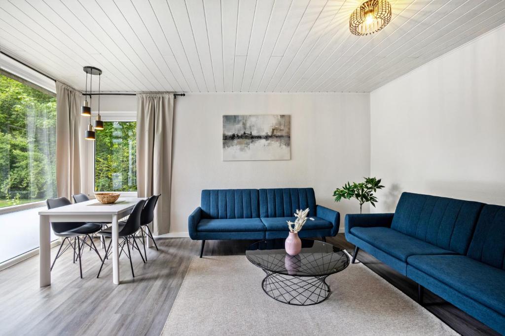 a living room with blue couches and a table at Kleine Seeperle in Quickborn