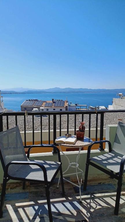two chairs and a table on a balcony with the ocean at Avra in Agia Galini
