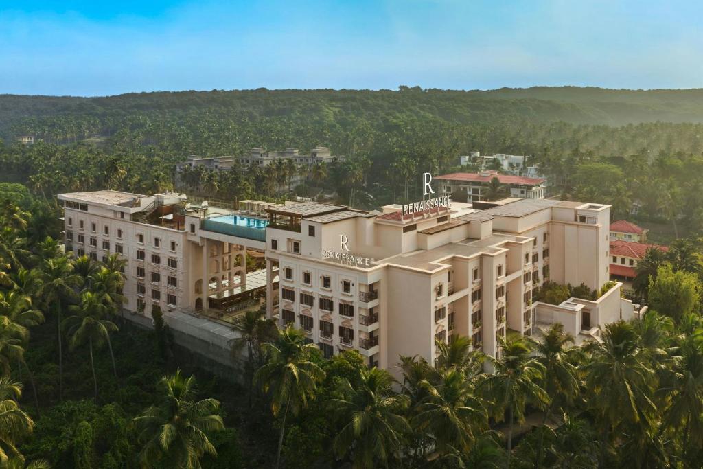 an aerial view of a building with palm trees at Renaissance Goa Hotel in Goa